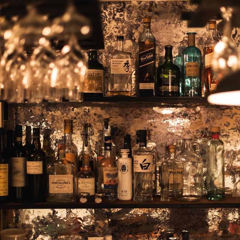 Assorted liquor bottles on a bar shelf