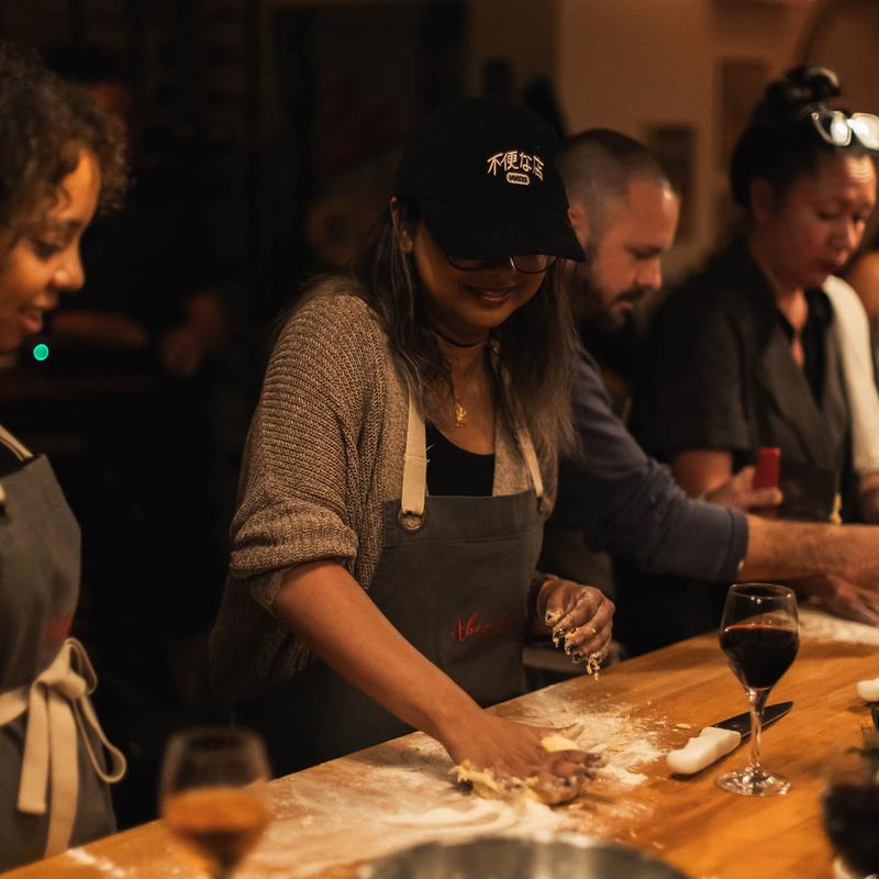 People learning to make fresh pasta in a cooking class