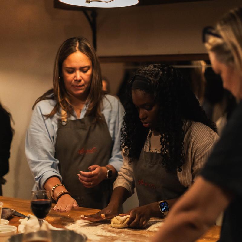 Two students kneading dough during a cooking class